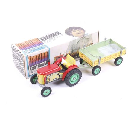 A clockwork tin plate toy tractor and trailer, boxed. By S. Valnikem, key present.
