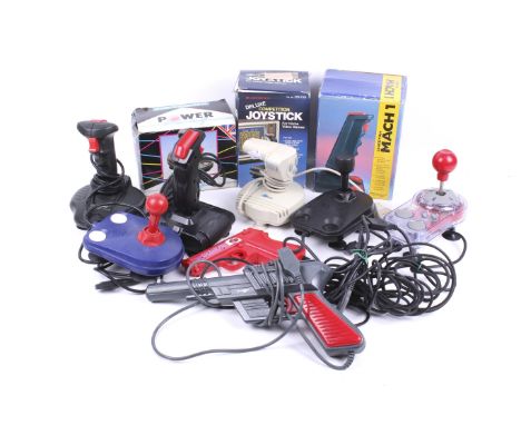 A collection of vintage video game joystick controllers. Noting the Cheetah Mach 1 in original box plus a range of others, qt