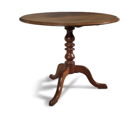 A GEORGE III STYLE MAHOGANY CIRCULAR STYLE TILT-TOP TEA TABLE the circular top with moulded rim, raised on turned support, wi