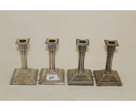 A set of four Victorian silver sheathed candlesticks of reeded form on a stepped plinth base (by Edward Hutton for William Hu