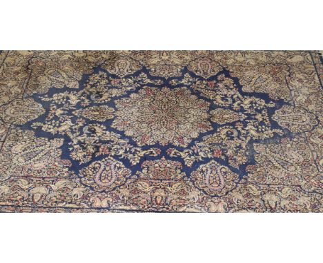 A Persian carpet with central floral medallion on a dark blue ground with all-over stylised floral decoration, 370 cm x 276 c