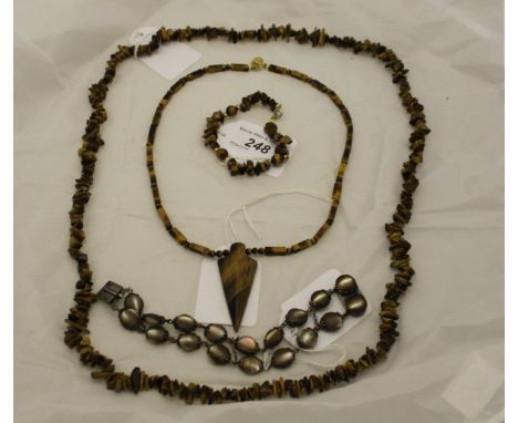 A tiger's eye necklace and similar bracelet, together with another tiger's eye necklace with arrow head shaped pendant, and a