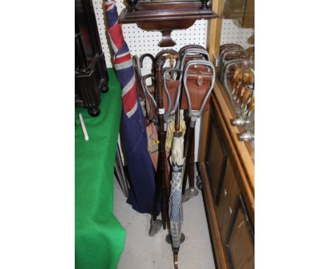A collection of seven various shooting sticks, three parasols, Victorian bamboo sheathed sword stick and a Union Jack flag on