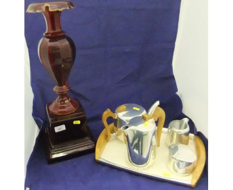 A large ruby glass vase raised on a ruby glass square plinth, together with a picqot ware tea set comprising teapot, hot wate