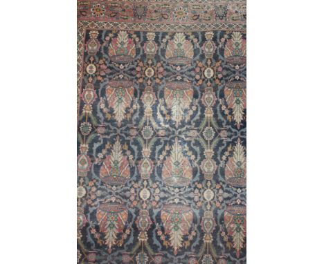 A Persian carpet, the dark blue centrefield with repeating stylised floral and foliate medallions in pale red, blue, cream an