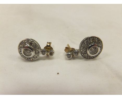 A pair of diamond set earring, the central stones each surround by ten smaller stones and two further stones to the top