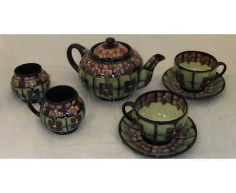 A Moorcroft tête à tête tea set in the "Violet" pattern, designed by Sally Tuffin, comprising teapot, jug, sugar bowl and two