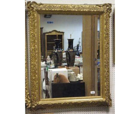 A pair of Victorian giltwood and gesso framed wall mirrors, the moulded frames with scrolling foliate and floral decoration i