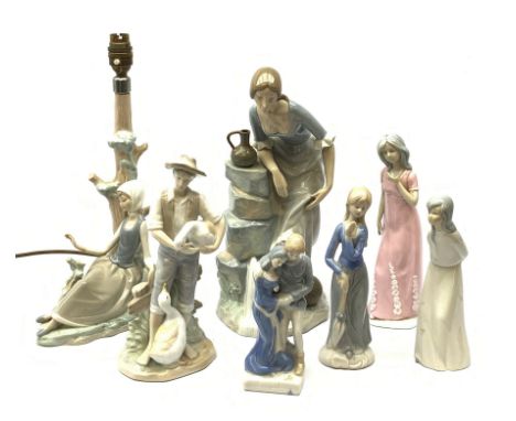 A group of figurines, to include a large Nao example, H32.5cm, and a Lladro table lamp, (a/f).  - Condition Report 