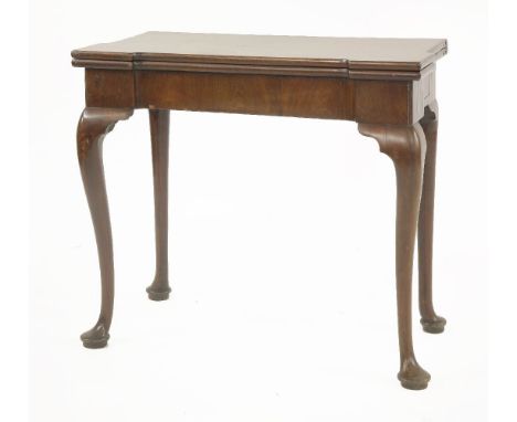 A George III mahogany fold-over card table,the shaped top opening to reveal counter wells, candlestands and a baize surface, 