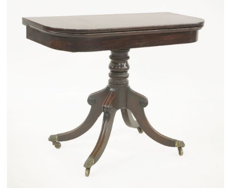 A George IV mahogany fold over card table,raised on a turned column and a moulded stand, mounted with brass caps and castors,