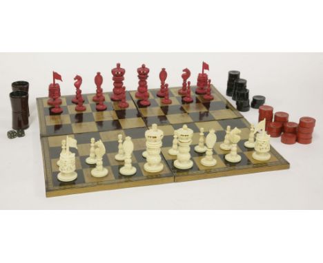 A carved ivory chess set,19th century, stained red and natural,king 8.5cm high,sixteen draughts pieces, andtwo papier mâché d