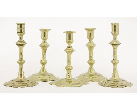 Two pairs of brass candlesticks,mid-18th century, each with petal bases,17 and 19.5cm high, andanother single candlestick,16.