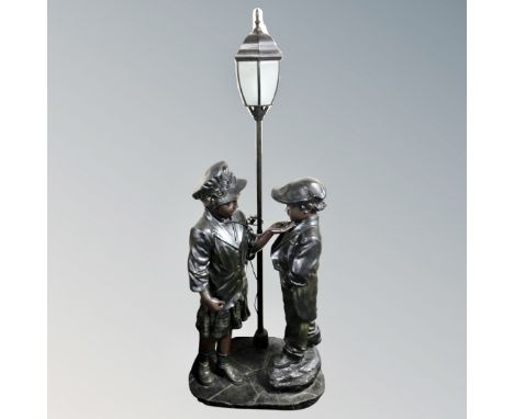 A contemporary figural floor lamp modelled as a boy and girl, height 172 cm.