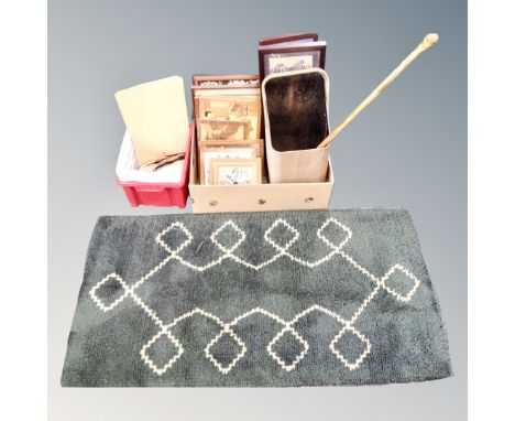 A vintage woolen rug and two boxes containing framed pictures, marquetry panels, art supplies, coal scuttle and walking stick