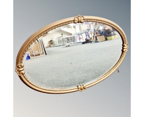 An antique gilt framed beaded oval mirror 