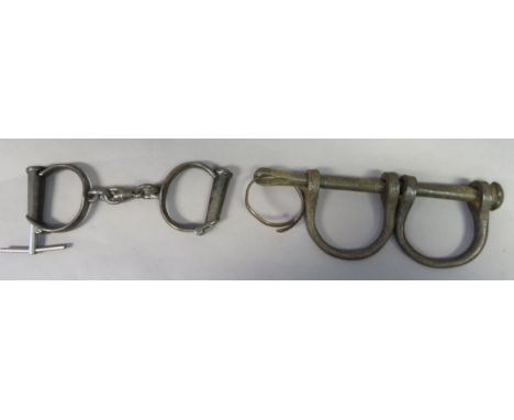 A PAIR OF LEG IRONS AND A PAIR OF CUFFS, 19TH/EARLY 20TH CENTURY the first 26.3 cm; 10 1/4 in (2)