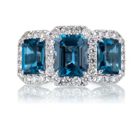 TOPAZ AND DIAMOND RING, set with three octagonal step cut London Blue topaz, within a diamond border totalling approximately 