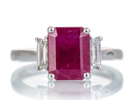 RUBY AND DIAMOND RING, set with an octagonal step cut ruby of approximately 2.76 carats, flanked by  baguette cut diamonds to