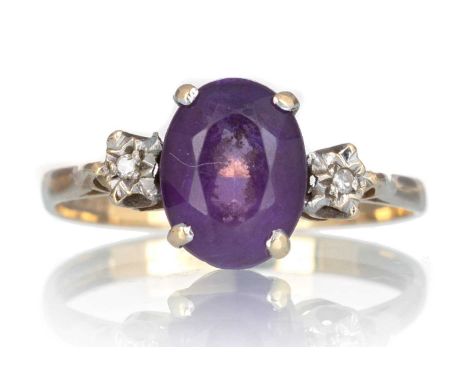 AMETHYST AND DIAMOND RING, the oval amethyst flanked by two small diamonds, in nine carat gold, size K 1/2Qty: 1.5g