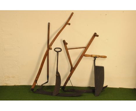 Two vintage scythes, one with split handle, the other a long handled example, together with a small scythe and two cutting to