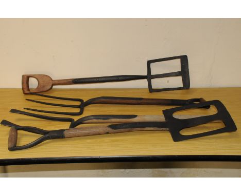 A group of vintage farm forks and digging tools, including two pierced spade shovels, an F. Parkes & Co two pronged fork, a p