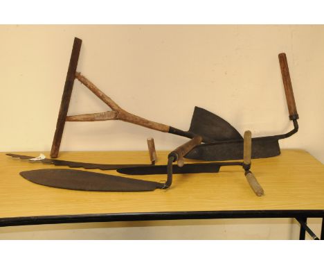 A group of five vintage hand cutting tools, including a peat cutter, a saw blade example and three others (5) 