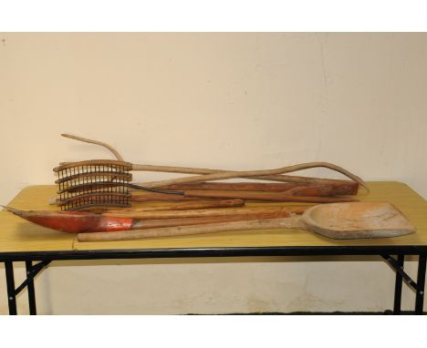 A group of antique and vintage wooden farm tools, including two pitch forks, a thrasher, two wooden shovels and more (parcel)