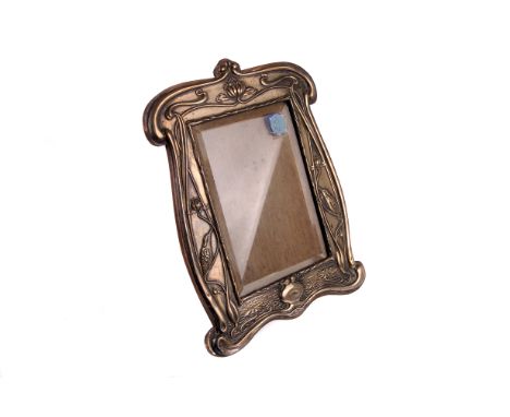 An Edwardian silver photograph frame by William Neale, Chester 1903, the shaped rectangular frame with Art Nouveau scrolls, b