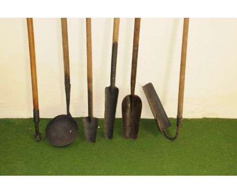 A group of six vintage drain and other farm long handled tools, including a bowl, an angle scoop, two with curved blades and 