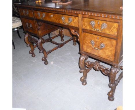 A mid-late 20th century walnut desk,  with light brown tooled leather, with a gadrooned top, over five drawers supported on s