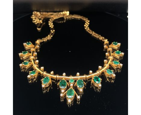 AN EMERALD AND DIAMOND NECKLACE. THE NECKLACE SET WITH 14 OVAL CUT GRADUATING EMERALDS AND ONE ROUND BRILLIANT CUT, IN A GEOM