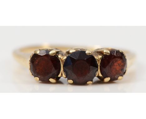 A 9ct gold garnet three stone ring, K, 1.8g 