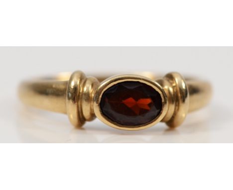 A 9ct gold oval cut garnet dress ring, bezel set, R, 2.8g 