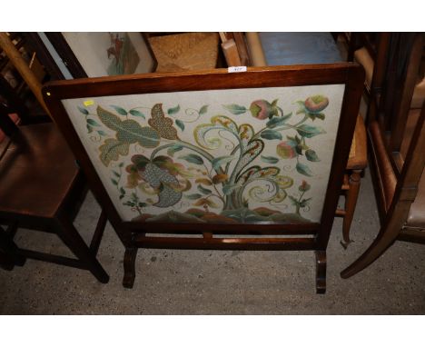 A mahogany framed fire screen with crewel work style embroidered decoration 