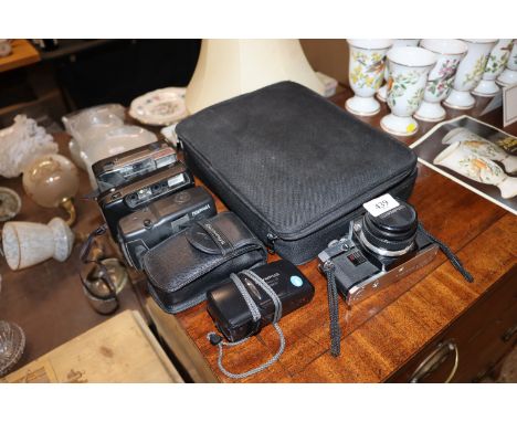 A Notebook computer; an Olympus OM10 camera and four other cameras