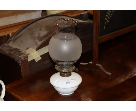 A Victorian opaque oil lamp with frosted glass shade