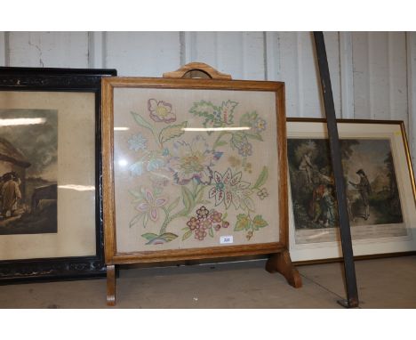 An oak framed fire screen with floral embroidered panel