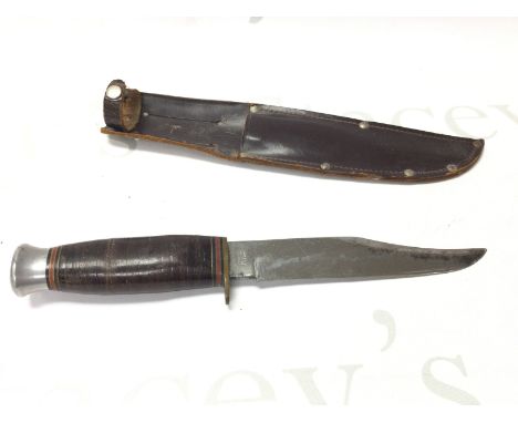 A hunting knife with leather scabbard