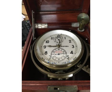 A Russian marine ships chronometer desk clock fitted in a mahogany brass Bound case .