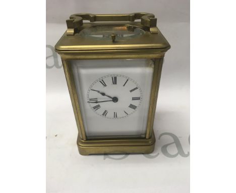 A brass carriage clock with repeat button movement the dial with Roman numerals 14 cm .