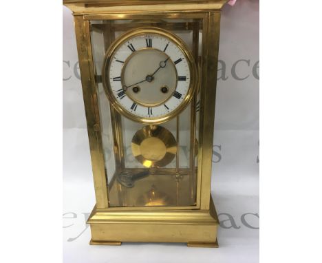 A brass four glass mantle clock the dial with Roman numerals visible pendulum striking on a gong ,