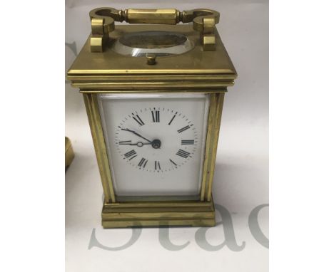 A brass case carriage clock The dial with Roman Numerals with repeat button movement