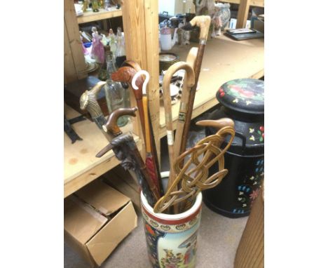 A collection of walking sticks in a ceramic stick stand. Shipping category D.