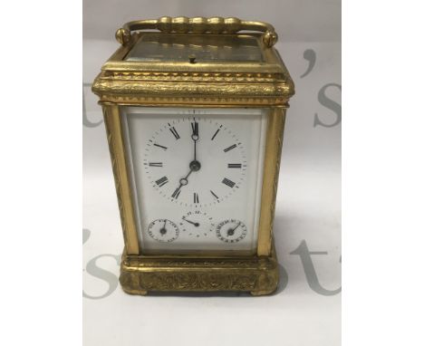 A gilt carriage clock With button repeat movement the dial with Roman numerals and day and month Subsidiary dials . 14 cm
