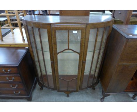 An oak bow front display cabinet