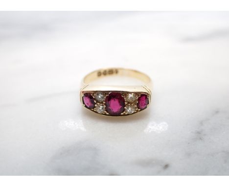 An Edwardian Ruby and Diamond Ring pavé-set three graduated oval-cut rubies with pairs of old-cut diamond between in 18ct gol