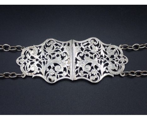 A Victorian silver two part Nurse's Buckle with pierced and engraved floral scroll design, with chain, Chester 1898, maker: N