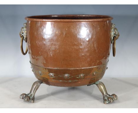 An antique copper Log Cauldron with lion mask ring handles, raised on paw supports, 15"Diameter. 