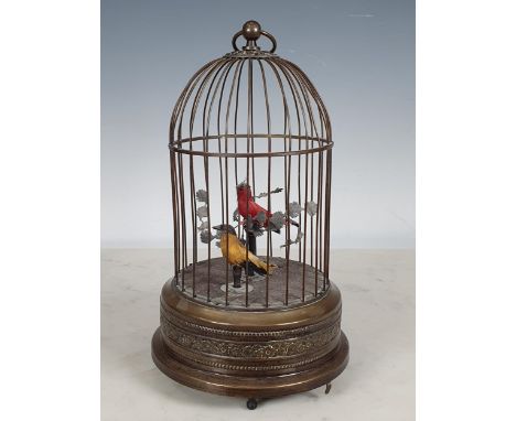 An early 20th Century Continental singing bird Automaton with two song birds on branch with foliage, the cage with floral emb